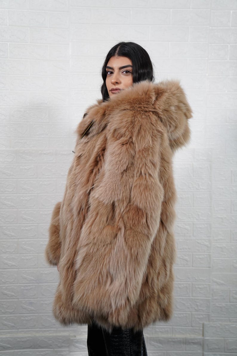 Person wearing a fur coat against a white textured wall