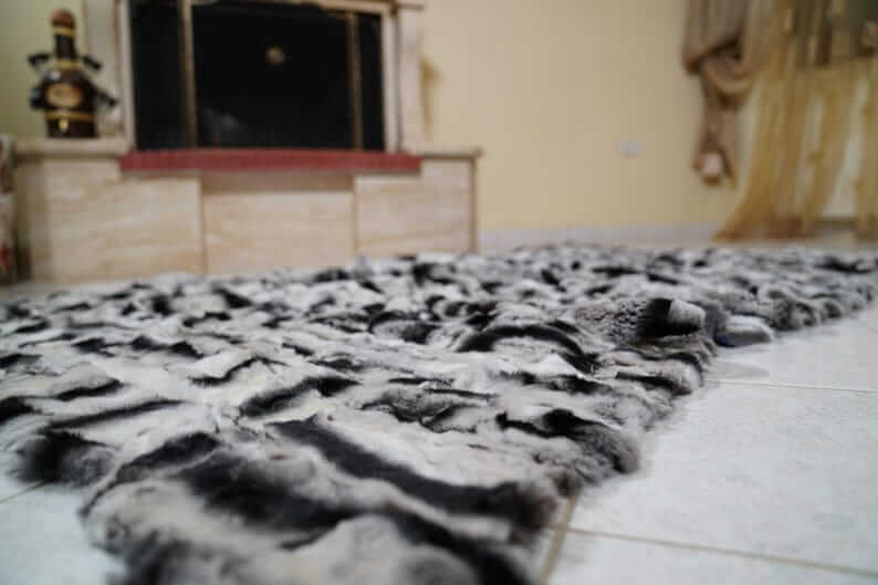 Rabbit Blanket Throw Chinchilla Rex - Tatifurs displayed on the floor, showcasing its luxurious soft fur texture and stunning design.