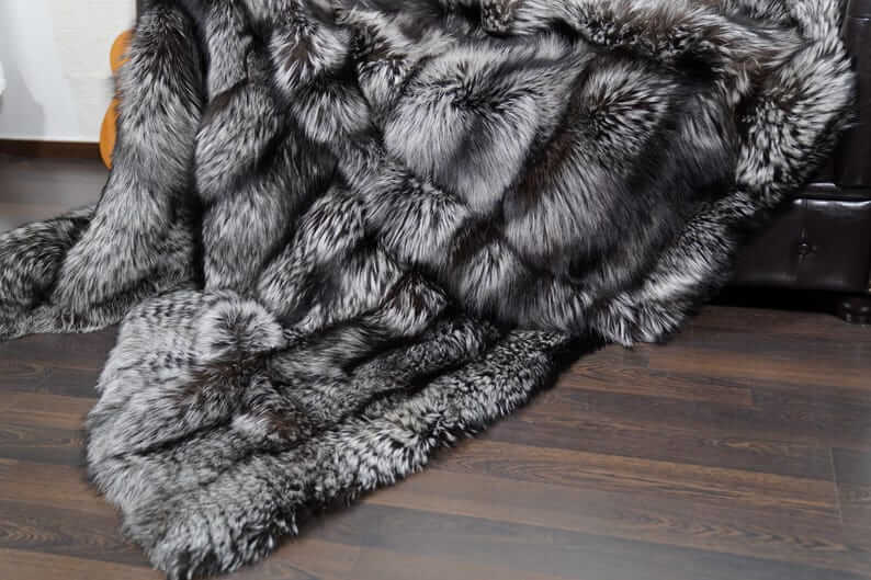 Fox Fur Blanket Throw Silver Natural - Tatifurs displayed on a hardwood floor, showcasing its luxurious silver fox fur texture.