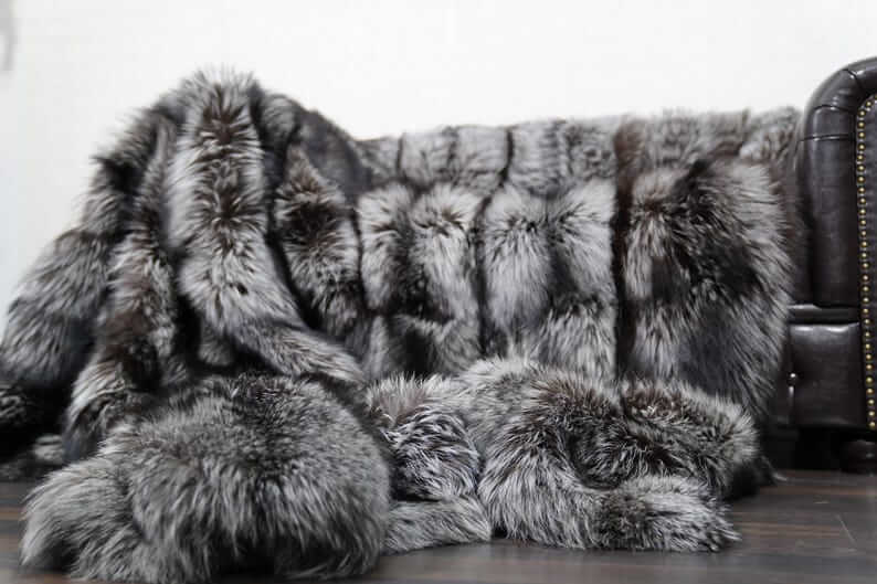 Fox Fur Blanket Throw Silver Natural - Tatifurs on a sofa, showcasing luxurious silver fox fur texture.