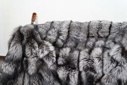 Fox Fur Blanket Throw Silver Natural - Tatifurs displayed on a surface, showcasing its luxurious silver fox fur texture.