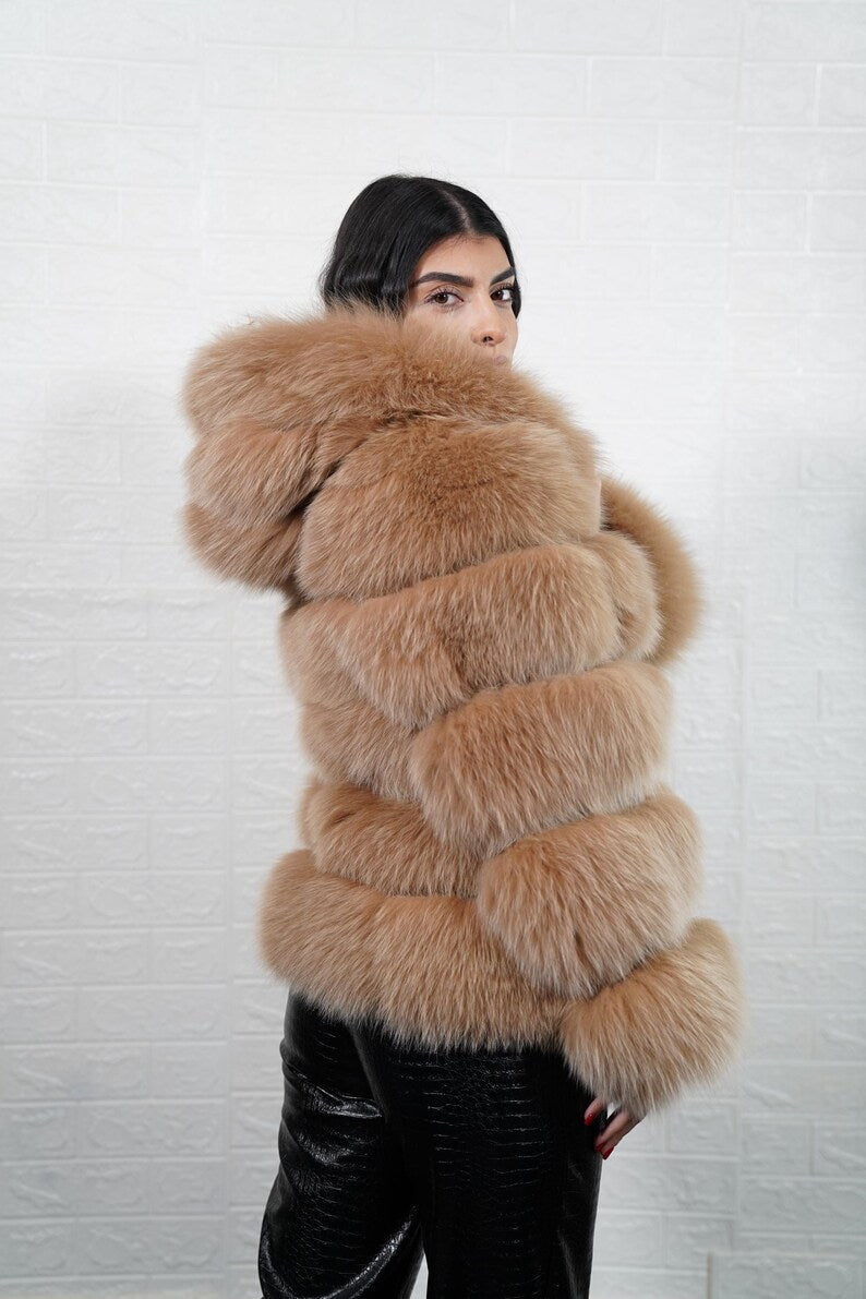 Luxury fashion detail of camel brown fur, leather lines, and hood
