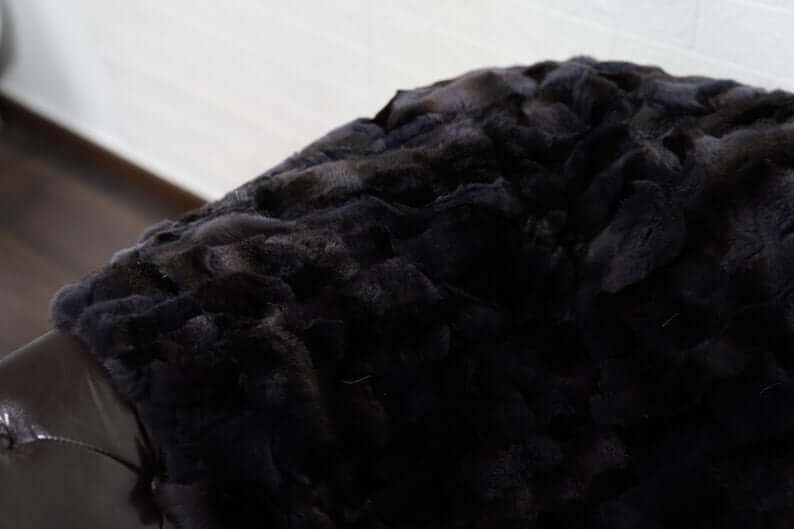 Rabbit Blanket Throw Rex Gray Orchid - Tatifurs draped over a couch showcasing its luxurious dark fur texture.