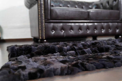 Rabbit Blanket Throw Rex Gray Orchid - Tatifurs displayed on a stylish floor near a vintage leather couch.