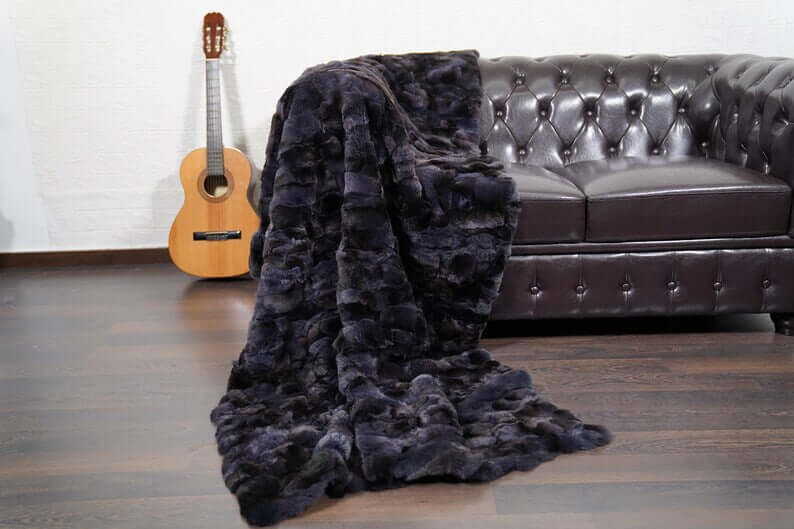 Rabbit Blanket Throw Rex Gray Orchid - Tatifurs draped on a couch with a guitar nearby, showcasing its luxurious texture.