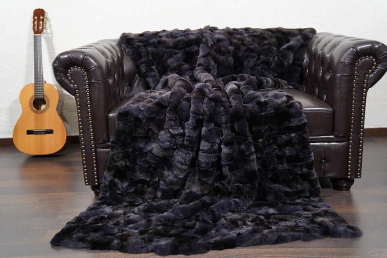 Rabbit Blanket Throw Rex Gray Orchid - Tatifurs on a leather sofa with a guitar.