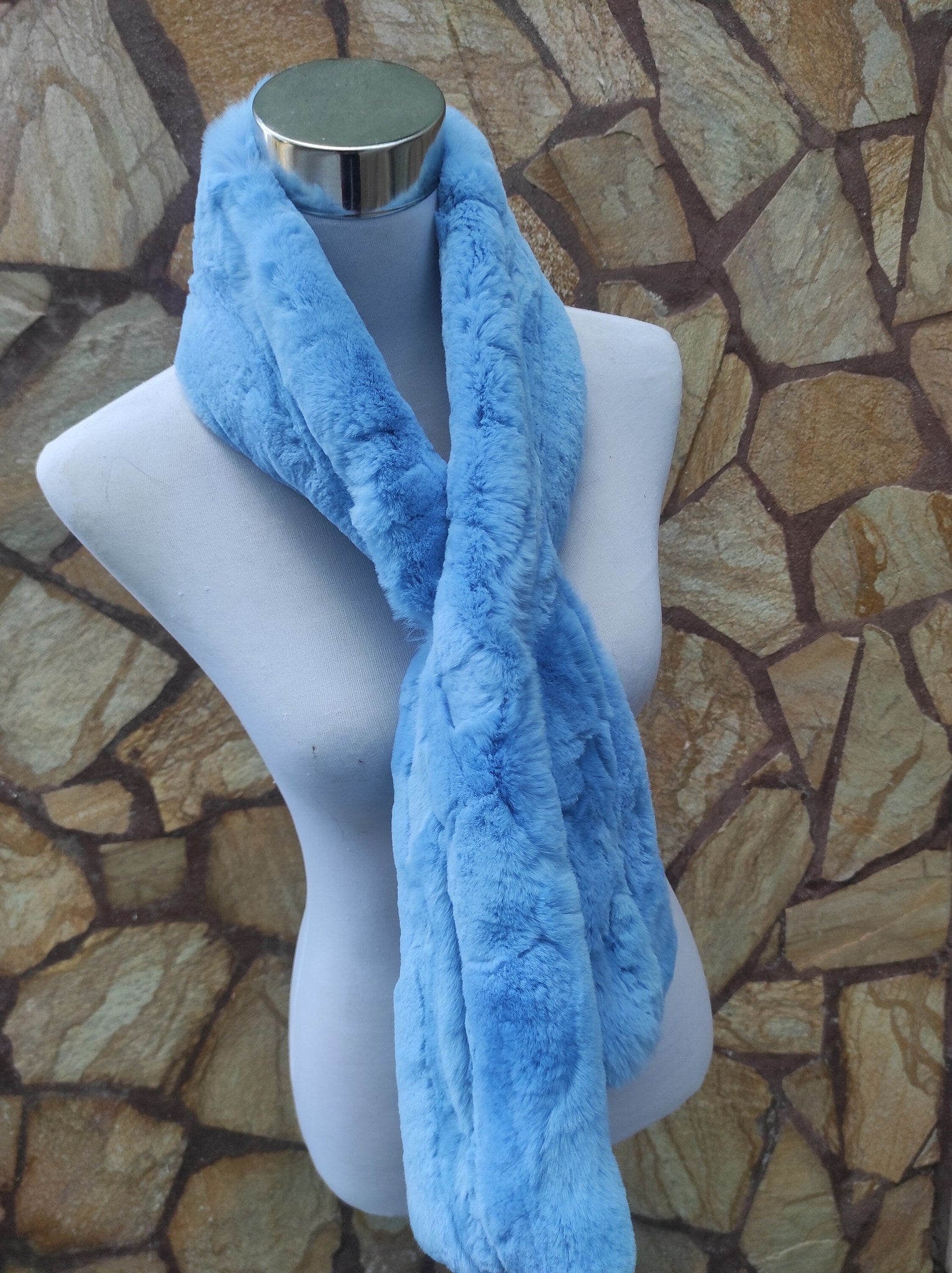 Rex Rabbit Fur Scarf Light Blue - Tatifurs displayed on a mannequin against a stone wall.