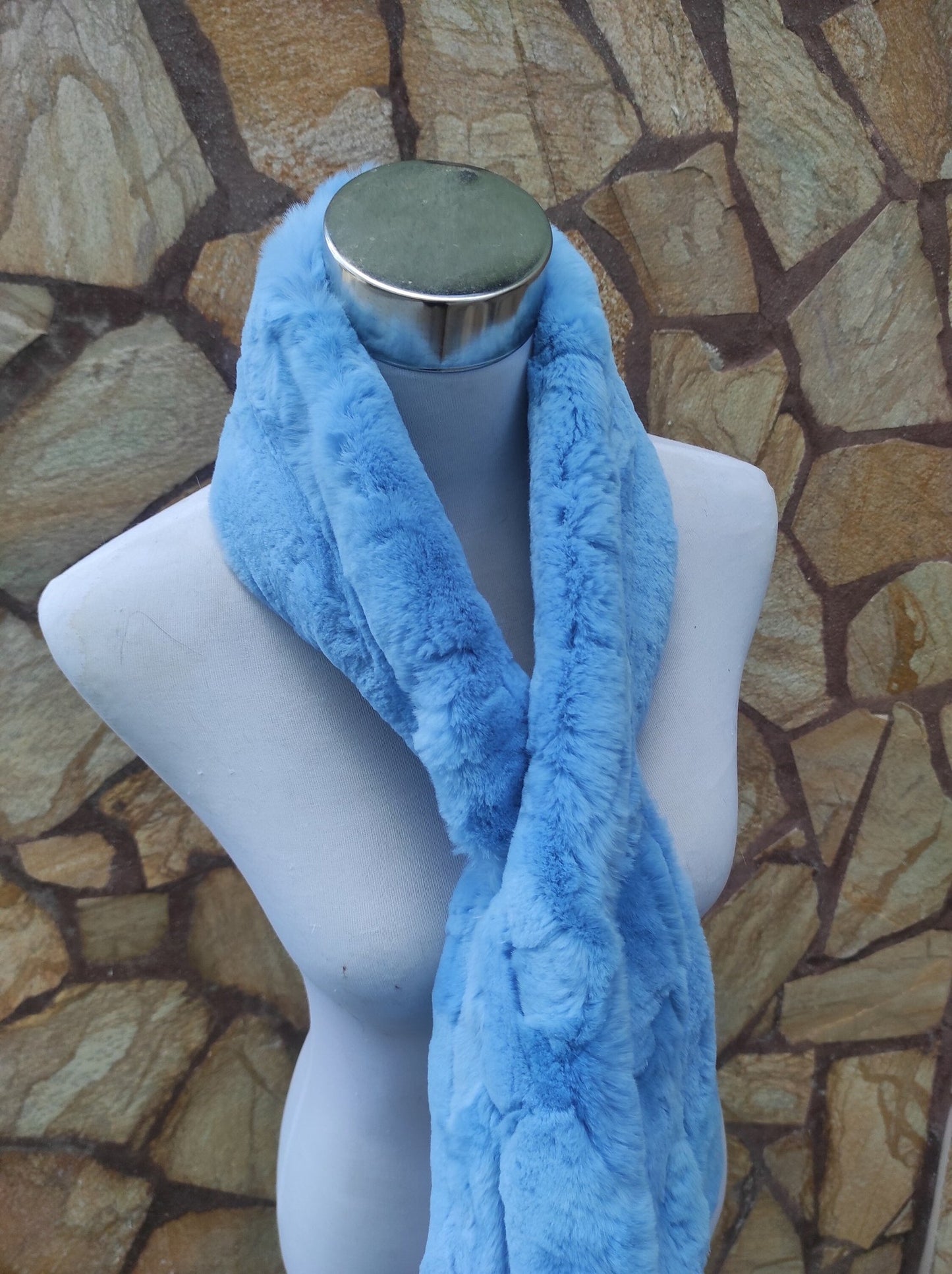 Rex Rabbit Fur Scarf Light Blue - Tatifurs displayed on a mannequin against a stone wall.