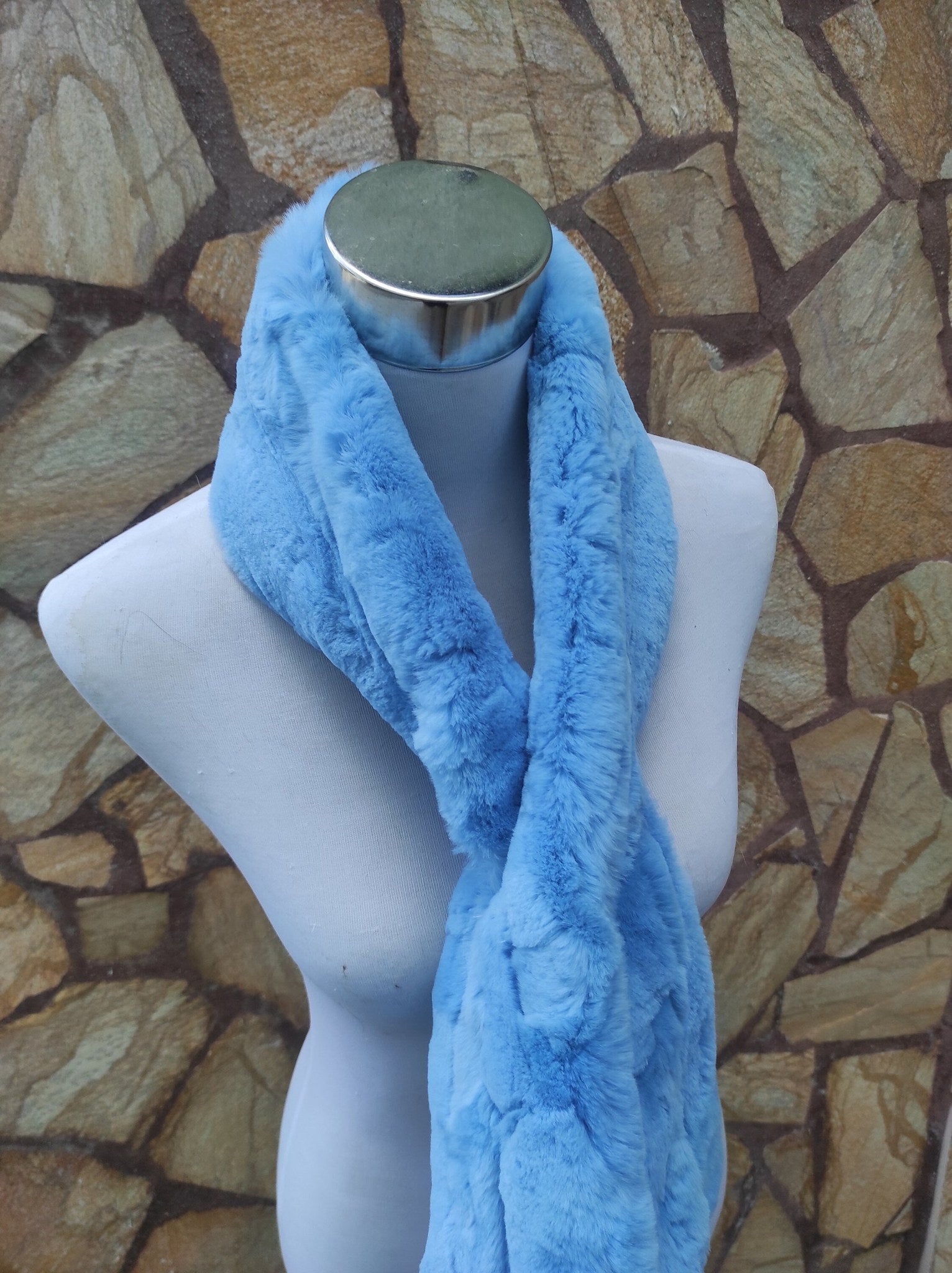 Rex Rabbit Fur Scarf Light Blue - Tatifurs displayed on a mannequin against a stone wall.