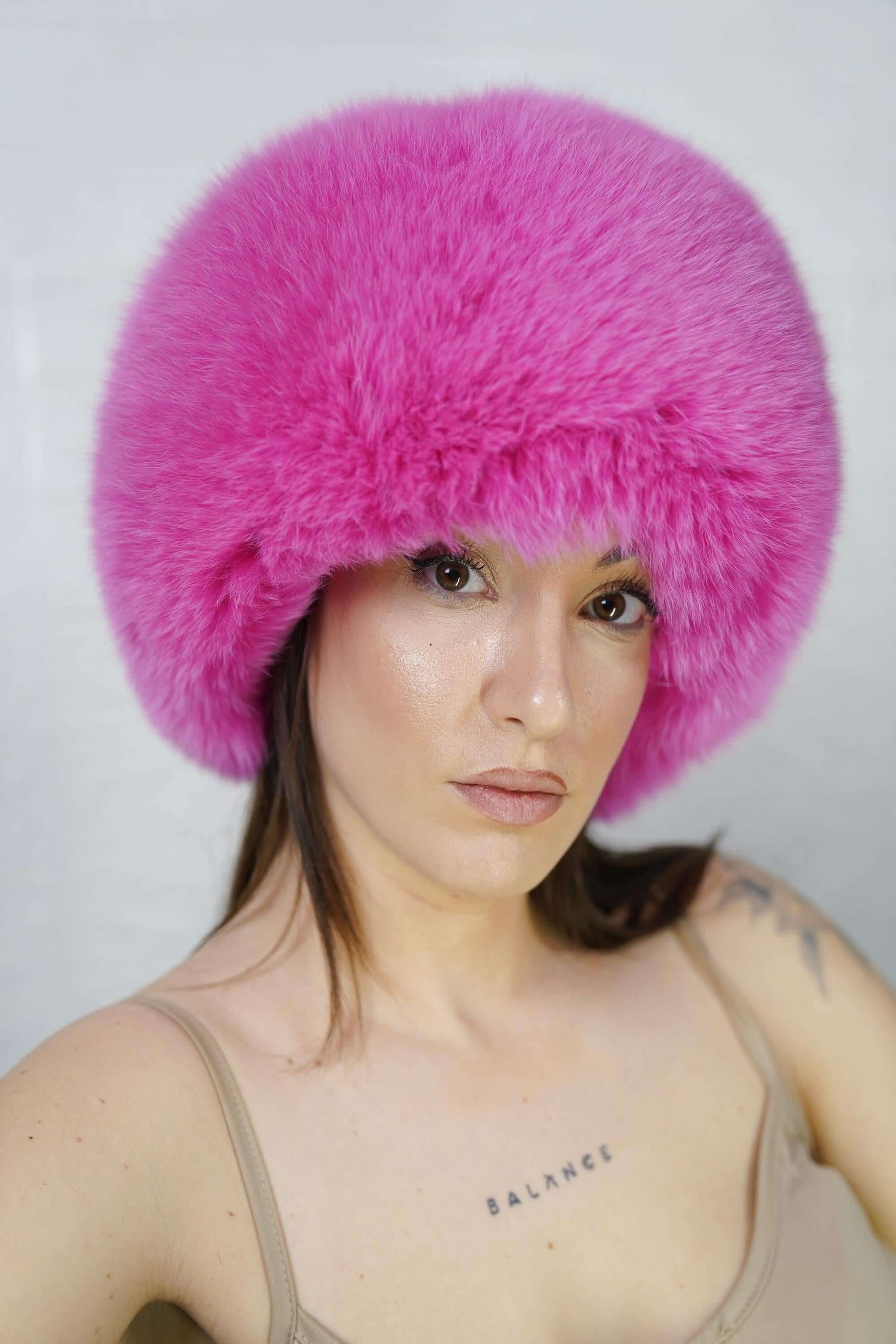 Fox Fur Hat Pink Full Skin - Tatifurs worn by a model, showcasing its vibrant fuchsia color and luxurious texture.