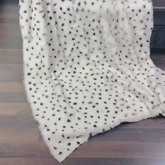 rabbit fur throw blanket dalmatian print — draped across black sofa, white and black graphic contrast — Greek craftsmanship, TatiFurs
