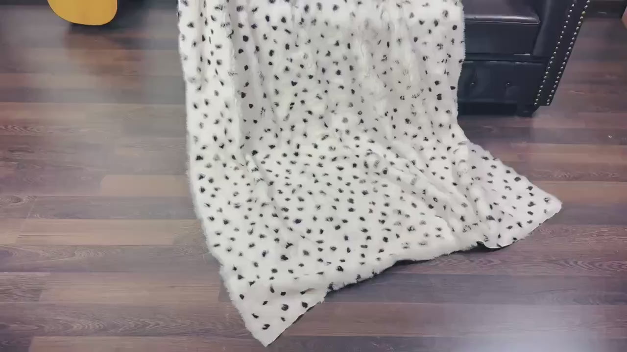 rabbit fur throw blanket dalmatian print — draped across black sofa, white and black graphic contrast — Greek craftsmanship, TatiFurs
