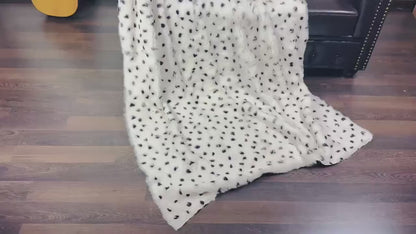 rabbit fur throw blanket dalmatian print — draped across black sofa, white and black graphic contrast — Greek craftsmanship, TatiFurs
