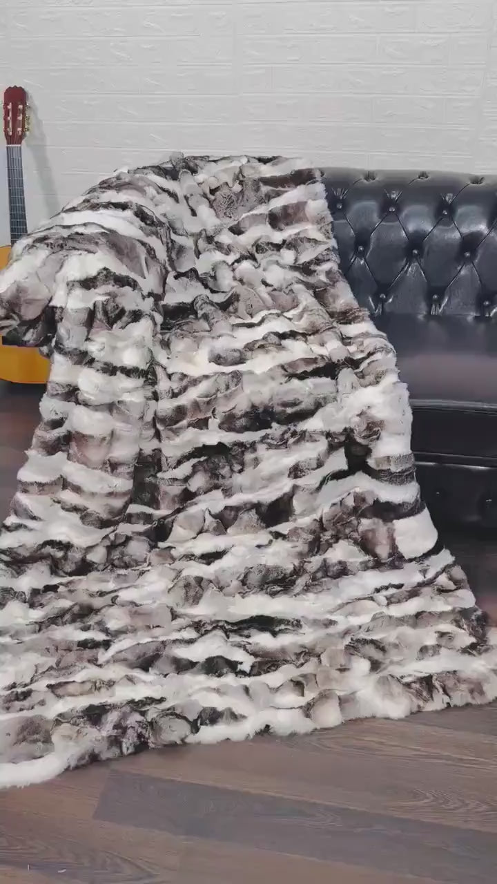 rex rabbit fur throw blanket natural black white — draped across white sofa, natural pattern against clean interior — Greek craftsmanship, TatiFurs
