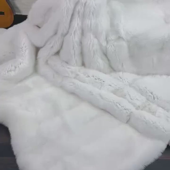 White Fox Fur Throw Blanket - Tatifurs draped elegantly over a couch, showcasing its luxurious pure white fur.