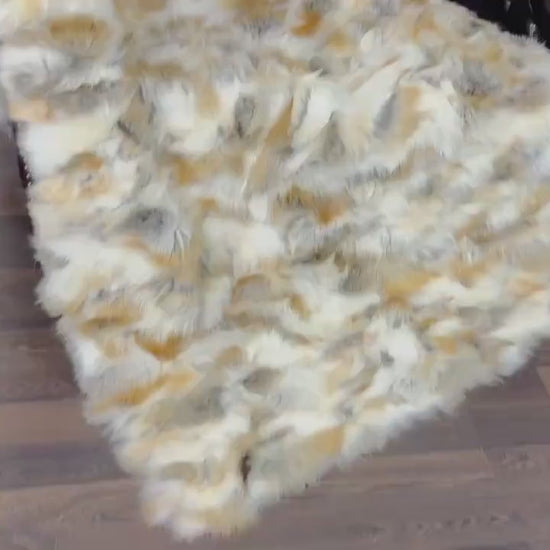 Fox Fur Blanket Throw Golden - Tatifurs displayed on a chair, showcasing its luxurious golden hues and plush texture.