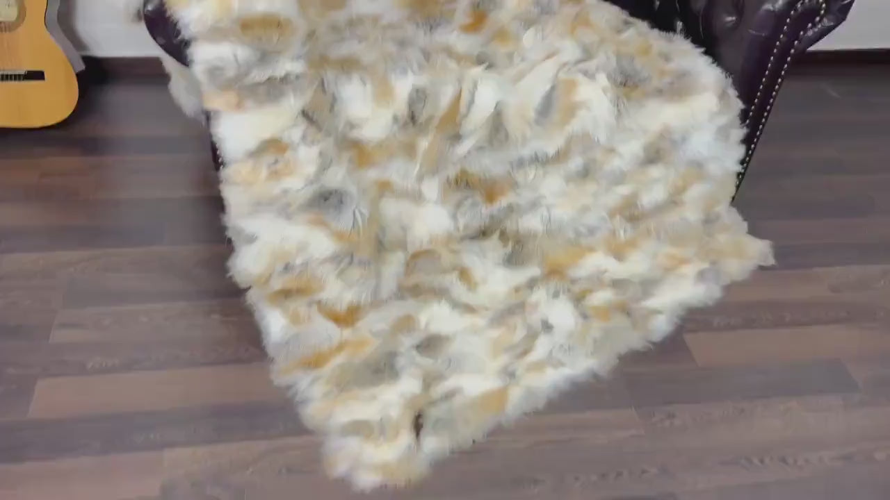Fox Fur Blanket Throw Golden - Tatifurs displayed on a chair, showcasing its luxurious golden hues and plush texture.