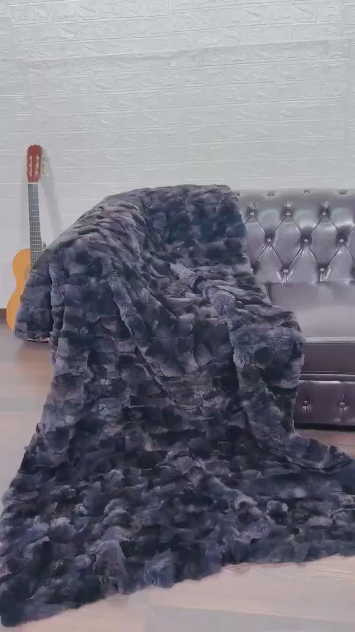 Rabbit Blanket Throw Rex Gray Orchid - Tatifurs draped over a brown leather couch, adding a touch of elegance to the room.