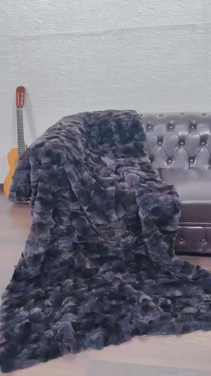 Rabbit Blanket Throw Rex Gray Orchid - Tatifurs draped over a brown leather couch, adding a touch of elegance to the room.