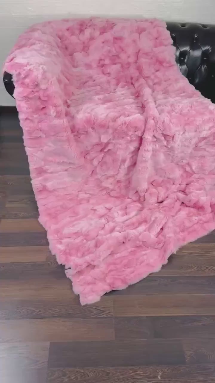 rex rabbit fur throw blanket pink — draped across white sofa, soft pink against clean base — Greek craftsmanship, TatiFurs
