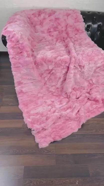 rex rabbit fur throw blanket pink — draped across white sofa, soft pink against clean base — Greek craftsmanship, TatiFurs

