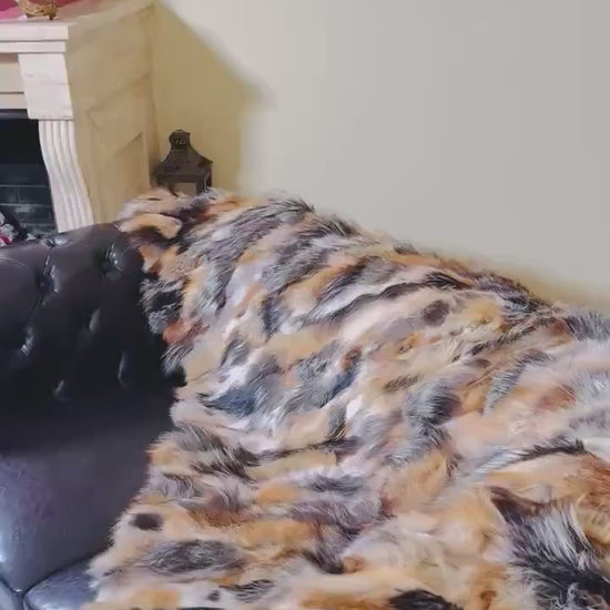 Fur Throw Blanket Natural Gross Fox – Luxury - Tatifurs draped over a luxurious couch, showcasing dramatic fur colors.