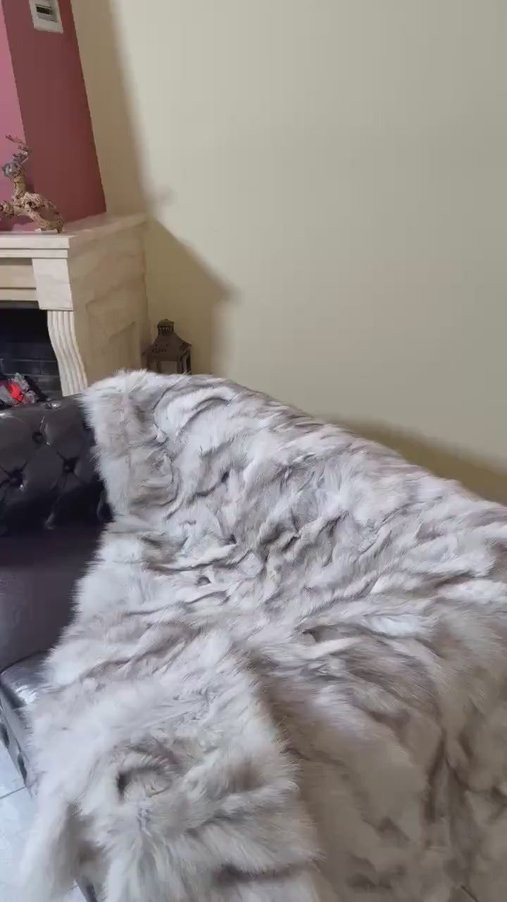 Fox Fur Blanket Throw Blue Natural - Tatifurs displayed on a stylish sofa, showcasing its luxurious texture.