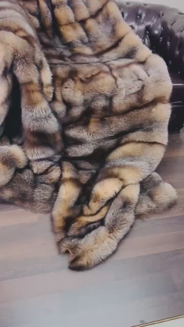 Natural Crystal Fox Fur Blanket - Tatifurs draped elegantly on a sofa, showcasing soft brownish white tones.