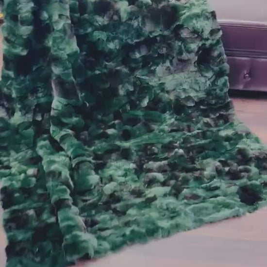 Rabbit Blanket Throw Rex Green Black - Tatifurs draped on a couch, showcasing its vibrant green and black fur texture.