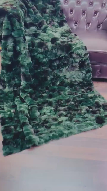 Rabbit Blanket Throw Rex Green Black - Tatifurs draped on a couch, showcasing its vibrant green and black fur texture.