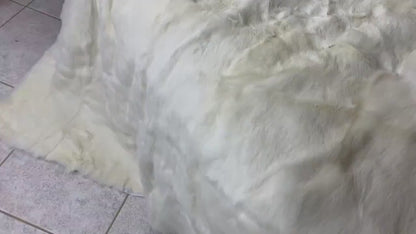 White Rabbit Fur Throw Blanket - Tatifurs displayed on a tiled floor, showcasing its soft and luxurious texture.