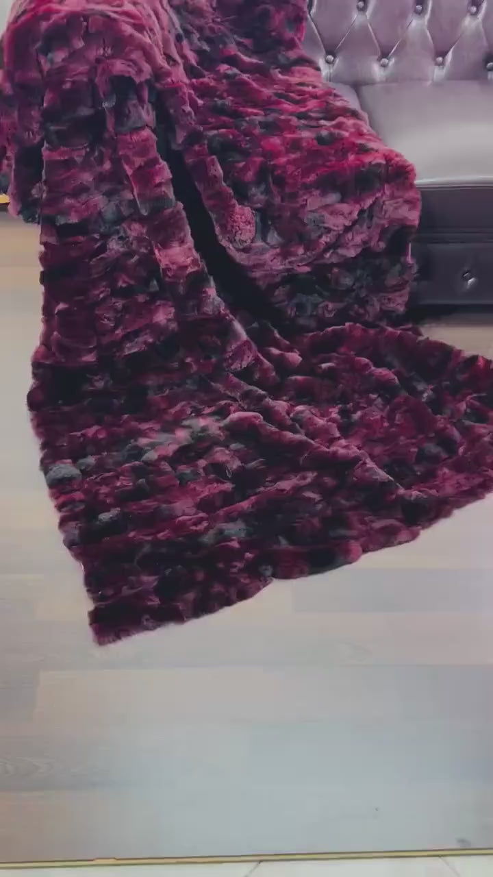 rex rabbit fur throw blanket red black — draped across dark sofa, commanding colour contrast — Greek craftsmanship, TatiFurs
