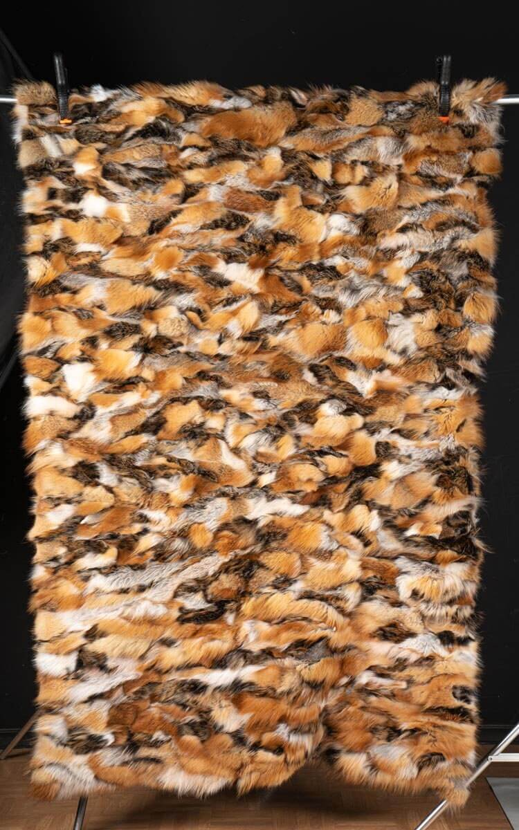 Fox Fur Blanket Throw Red Canadian Dark - Tatifurs displayed on a hanger, showcasing rich fur textures and colors.