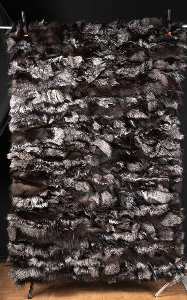 Fox Fur Blanket Throw Silver Dark - Tatifurs displayed on a stand, showcasing deep silver and charcoal fur textures.