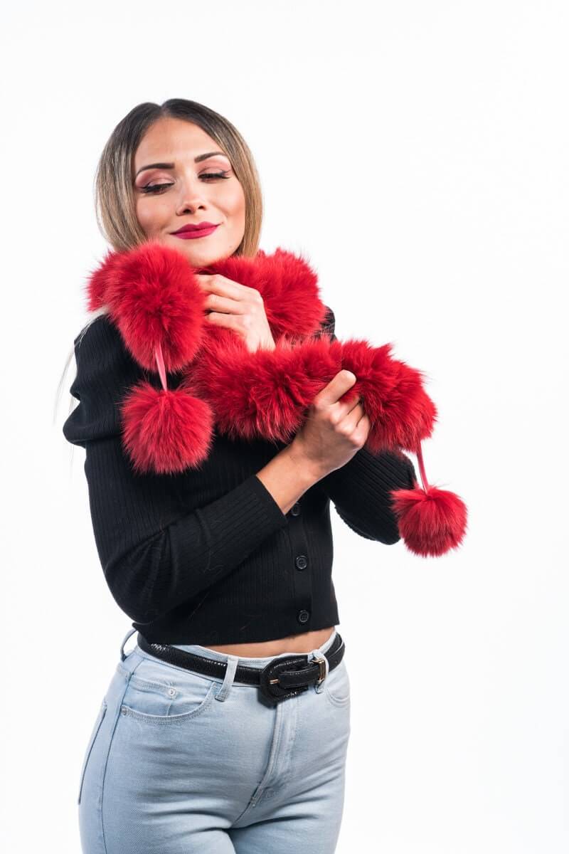 Red Fox Fur Scarf with Pom Poms - Tatifurs being modeled by a woman, showcasing its vibrant red color and playful design.