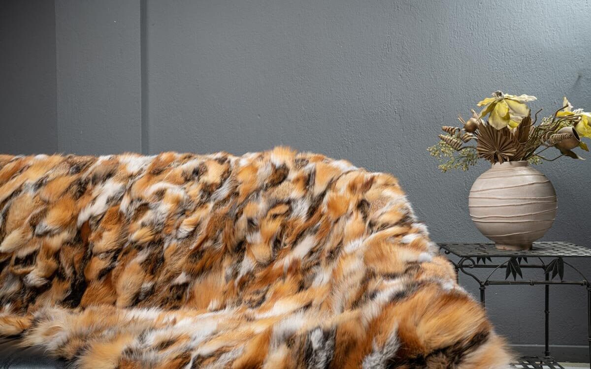 Fox Fur Blanket Throw Red Canadian Dark - Tatifurs draped elegantly over sofa with decorative vase.