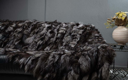 Darker natural silver fox fur blanket draped over bed showing rich charcoal and deep silver tones
