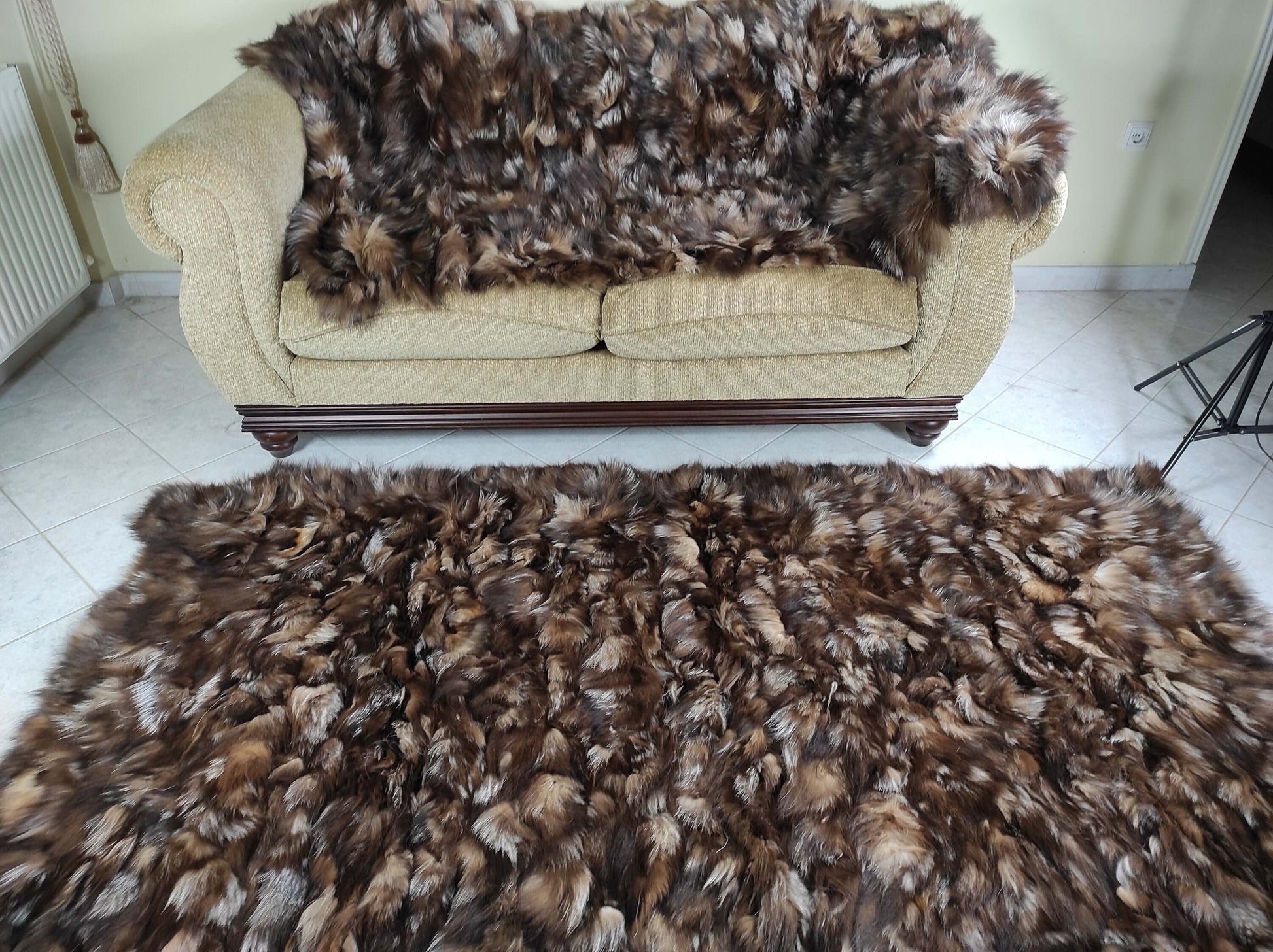 Fox Fur Blanket Throw Crystal Dark - Tatifurs displayed on a sofa and floor rug showcasing rich textures and colors.