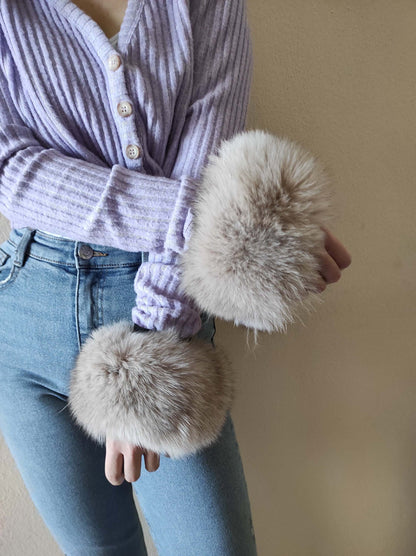 Gray Fox Fur Cuffs - Tatifurs worn on wrists with a soft lavender sweater and denim jeans.