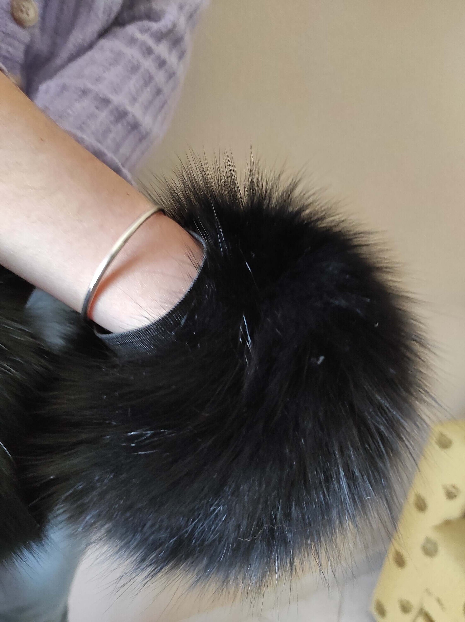 Black Fox Fur Cuffs - Tatifurs worn on the wrist showcasing luxurious black fur texture and style.