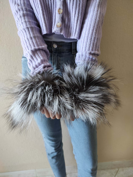 Woman wearing natural silver fox fur cuffs on wrists showing luminous silver tones
