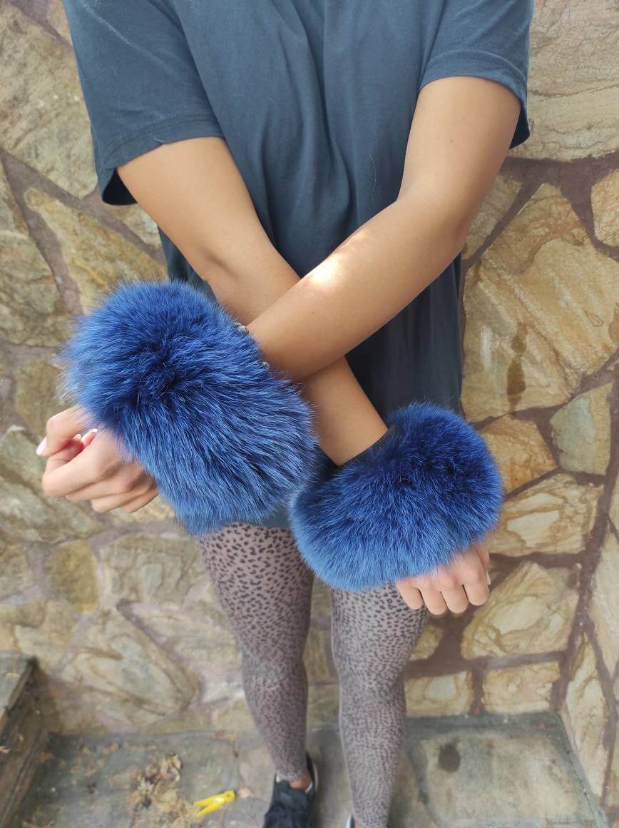 Blue Fox Fur Cuffs - Tatifurs worn on wrists, showcasing bold blue color and luxurious texture.
