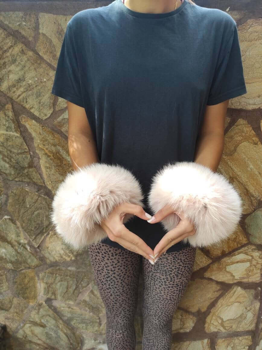 Model wearing Baby Pink Fox Fur Cuffs - Tatifurs, showcasing soft blush fur in an elegant pose.