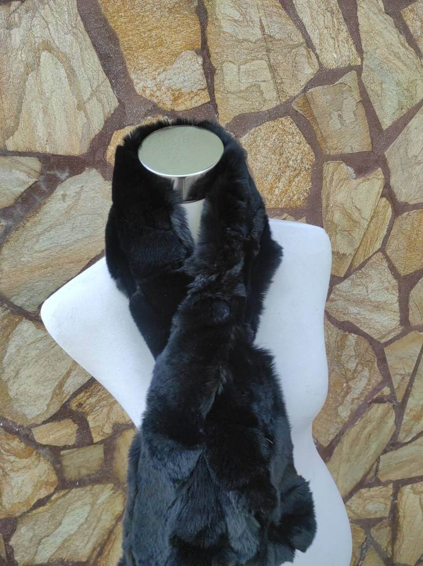 Rex Rabbit Fur Scarf Black - Tatifurs displayed on a mannequin against a stone wall background.