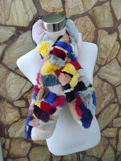 Rex Rabbit Fur Scarf Colorful - Tatifurs displayed on a mannequin against a stone background, showcasing vibrant colors.