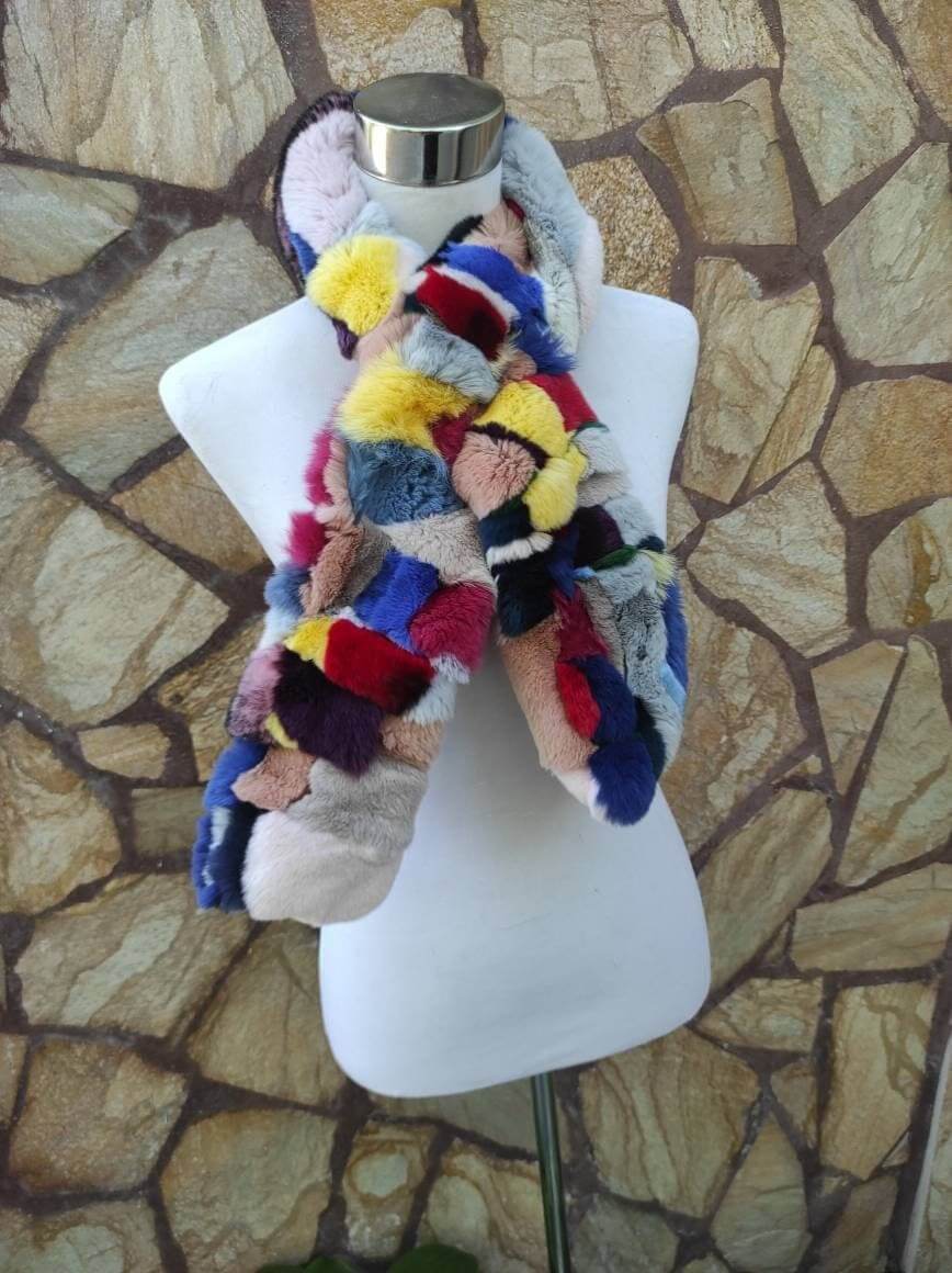 Rex Rabbit Fur Scarf Colorful - Tatifurs displayed on a mannequin against a natural stone background.