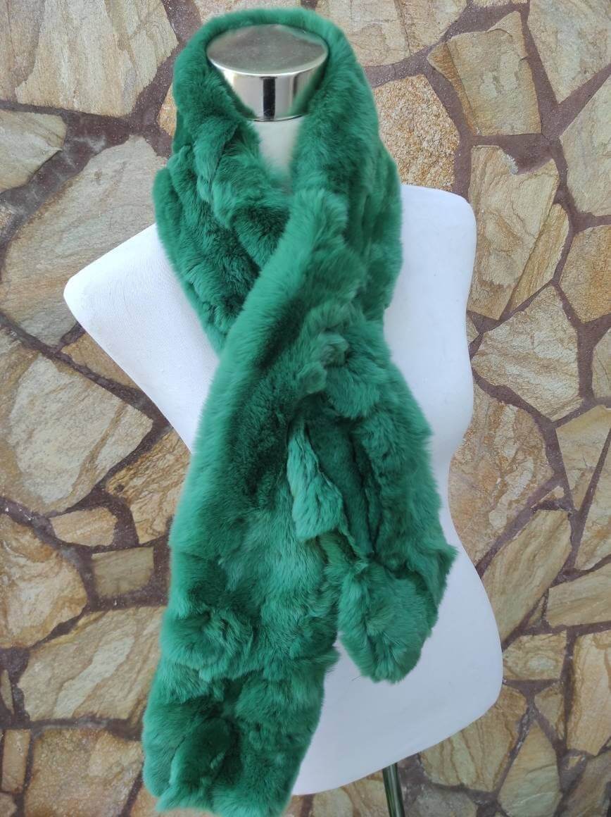 Rex Rabbit Fur Scarf Green - Tatifurs draped on a mannequin against a stone backdrop, showing its velvety texture.