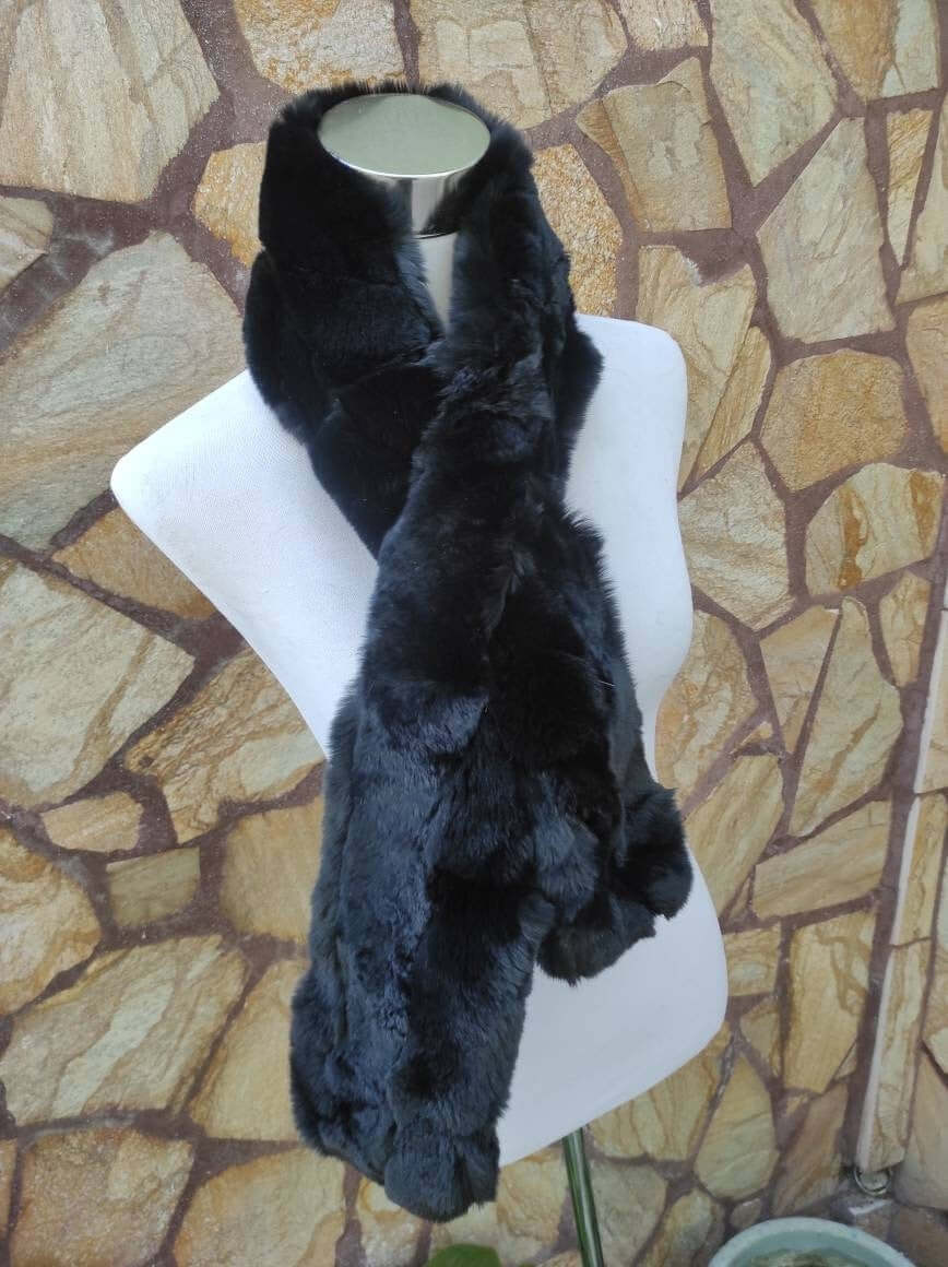 Rex Rabbit Fur Scarf Black - Tatifurs displayed on a mannequin against a stone wall.
