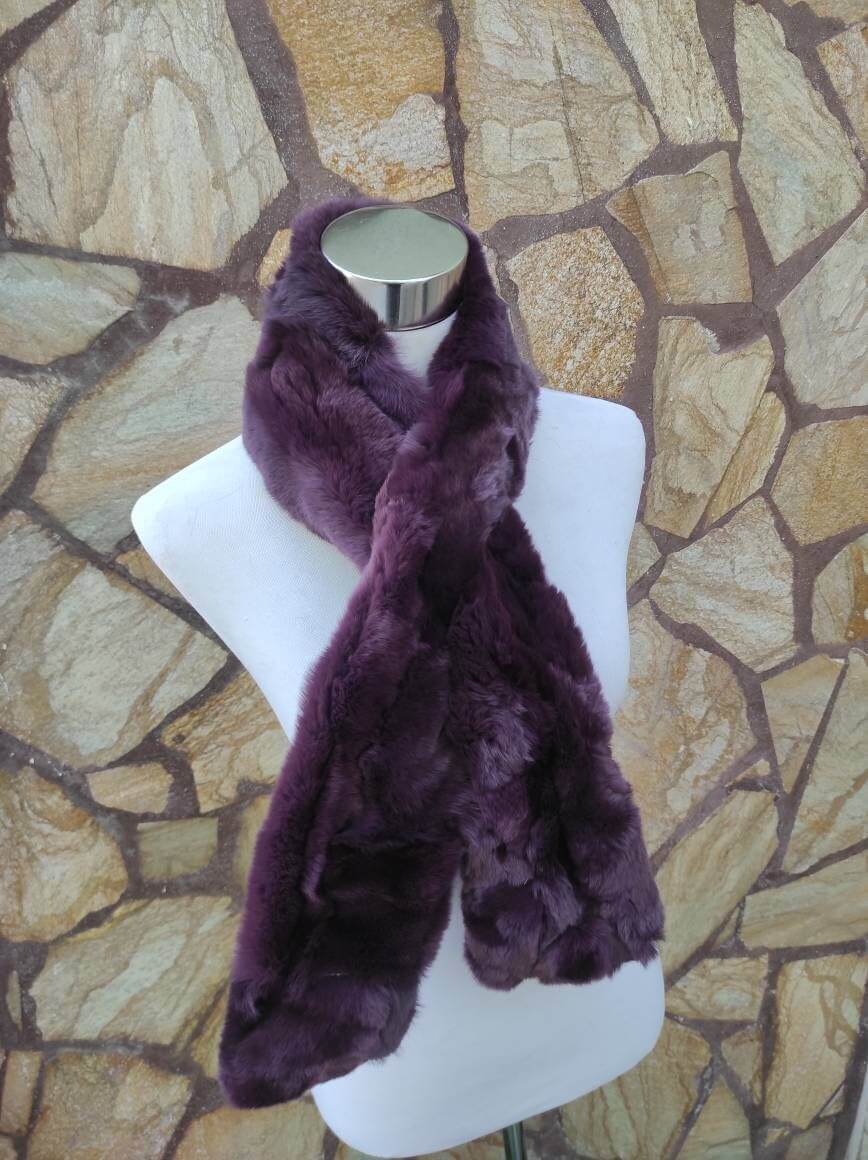 Rex Rabbit Fur Scarf Purple - Tatifurs elegantly displayed on a mannequin against a stone wall.