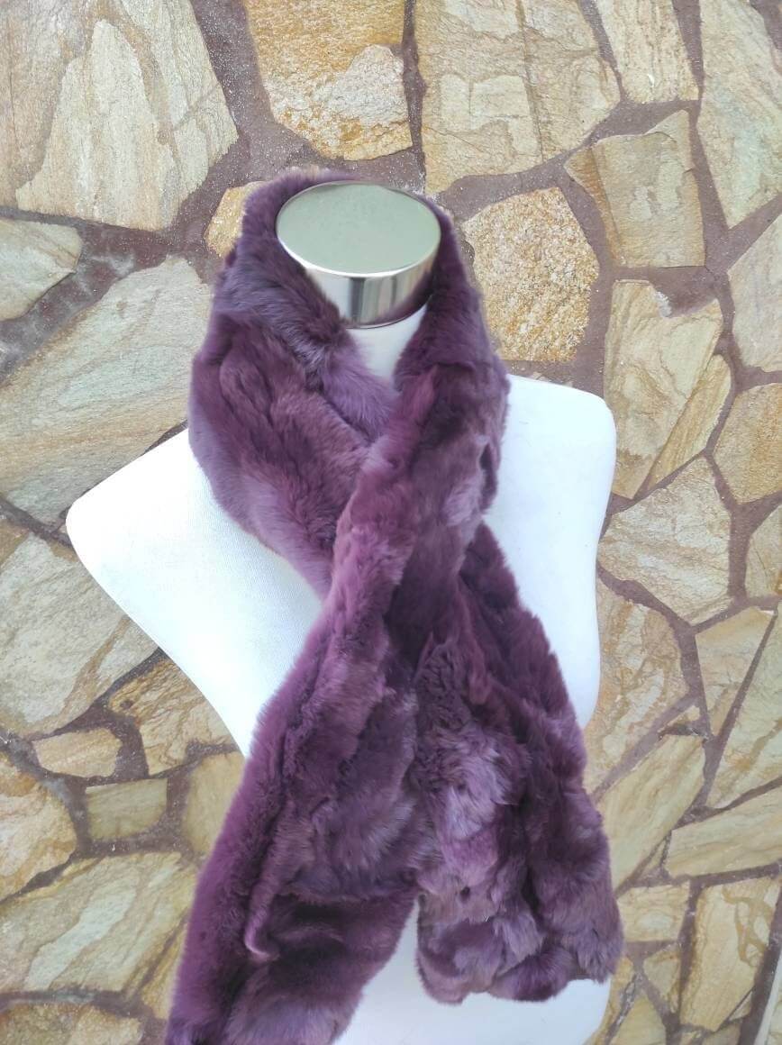 Rex Rabbit Fur Scarf Purple - Tatifurs displayed on a mannequin against a stone background, showcasing its rich purple color.